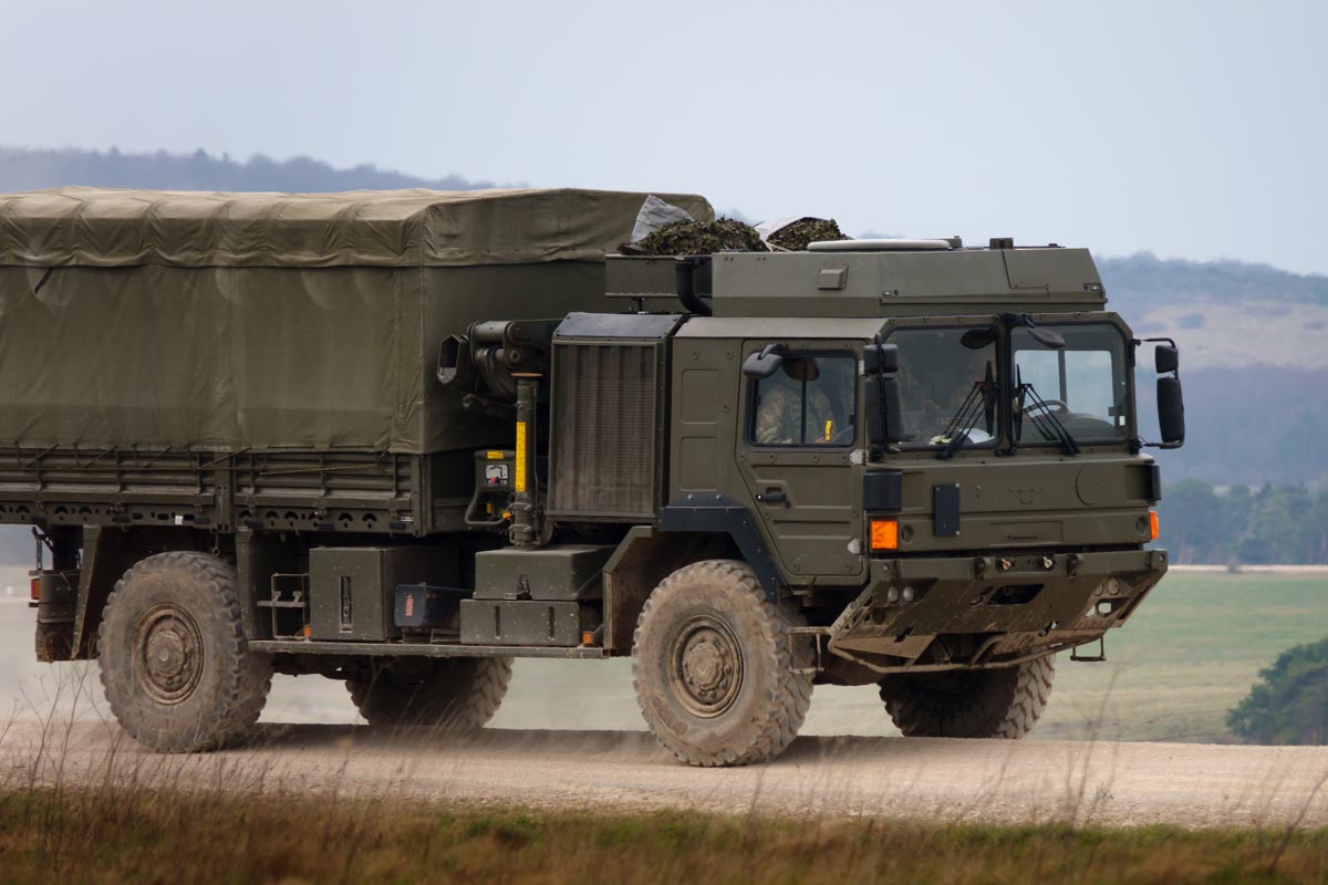 MAN SV 4x4 army logistics vehicle driving along a dusty stone and dirt track on maneuvers, Salisbury Plain Wiltshire